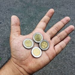 High angle view of hand holding coins