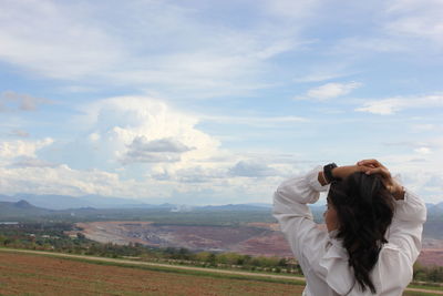 Woman standing on field against sky