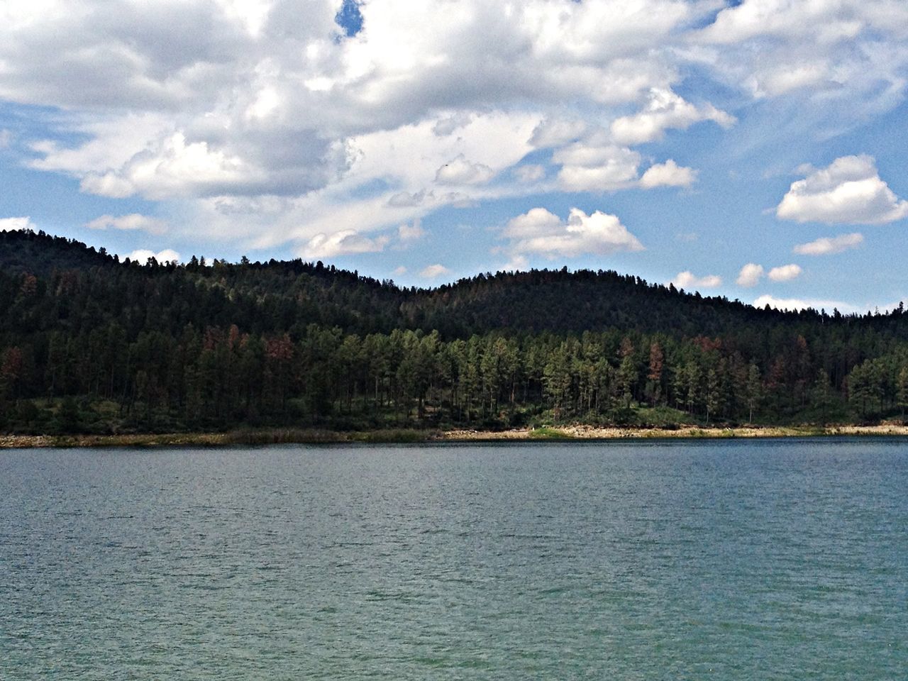 tranquil scene, water, sky, tranquility, scenics, mountain, waterfront, tree, beauty in nature, lake, cloud - sky, nature, cloud, mountain range, river, rippled, idyllic, landscape, non-urban scene, cloudy