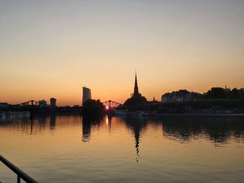 Reflection of buildings in city at sunset