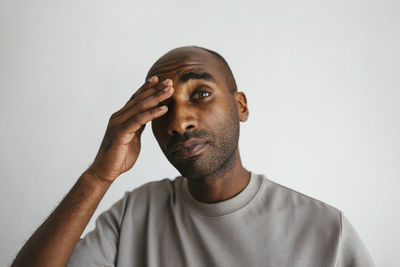 Man with head in hand against white background