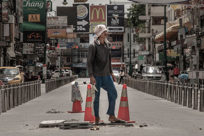 Full length of woman standing on street in city