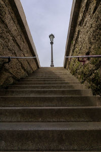Low angle view of steps amidst buildings against sky