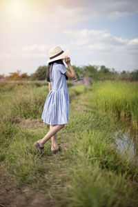 Rear view of woman standing on field