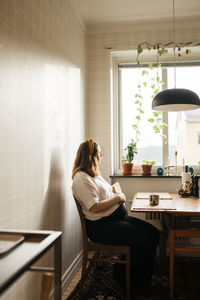 Pregnant woman sitting in kitchen