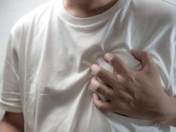 Midsection of man holding aching chest 