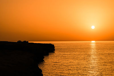 Scenic view of sea against orange sky