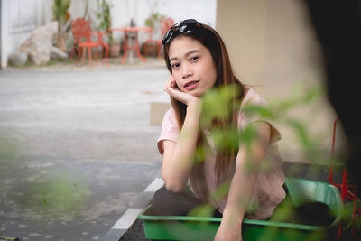 Young woman looking away while sitting outdoors