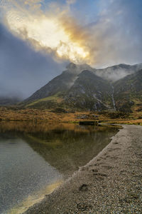 Scenic view of lake by mountains against sky