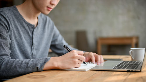 Midsection of man using laptop at office