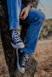 Low section of man sitting on land