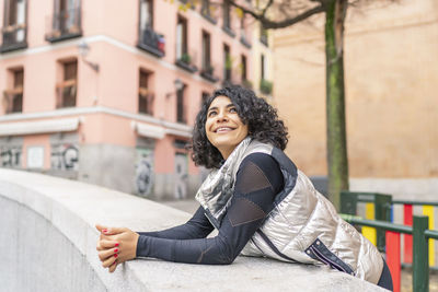 Portrait of smiling woman sitting in city