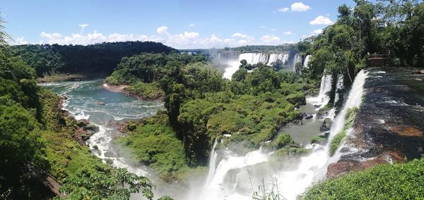 Scenic view of waterfall in forest against sky