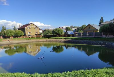 Scenic view of lake and houses against sky