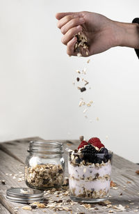 Midsection of person holding ice cream on table