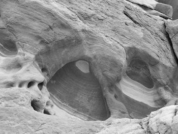 Black and white close up of a rock formation with pillars and caves