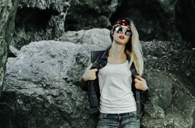 Portrait of young woman standing on rock