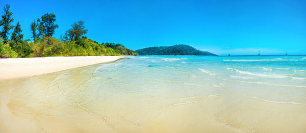 Scenic view of beach against clear blue sky