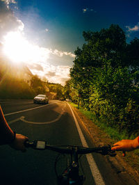 Man riding bicycle on road against sky