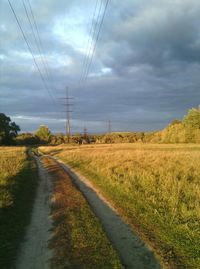 Road amidst field against sky