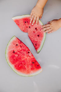 High angle view of hand holding red fruit on table