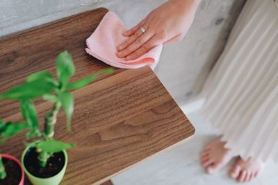 Midsection of woman holding cloth on table