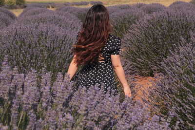 Rear view of woman standing on field