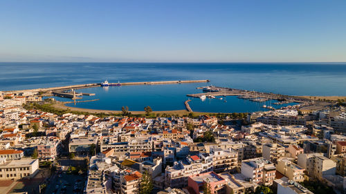 High angle view of townscape by sea against clear sky