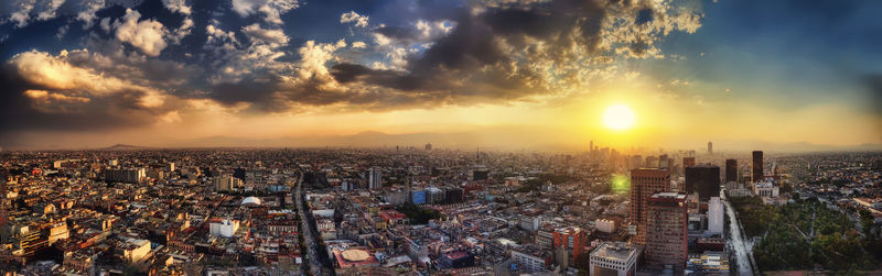 High angle view of modern buildings against sky during sunset