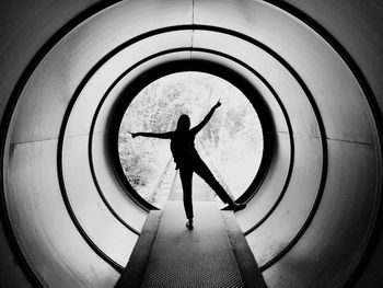 Rear view of silhouette man standing in tunnel