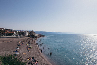 High angle view of people on beach against clear sky