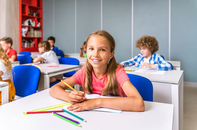 Portrait of smiling girl sitting at classroom