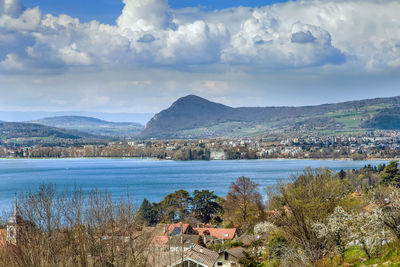 Scenic view of lake by townscape against sky