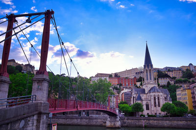 Bridge over river against buildings in city