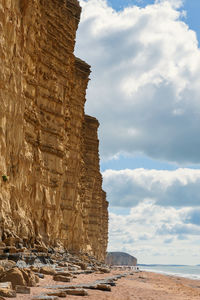 Rock formation on beach against sky