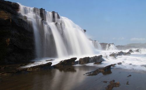 Scenic view of waterfall against sky