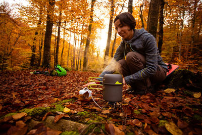 Side view of man sitting in forest