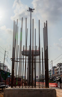 Low angle view of cranes against sky in city