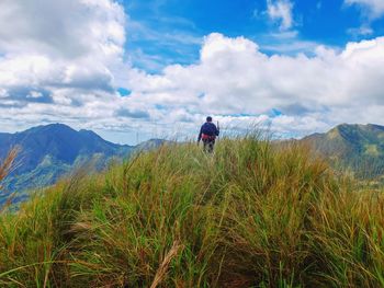 Rear view of man on mountain against sky