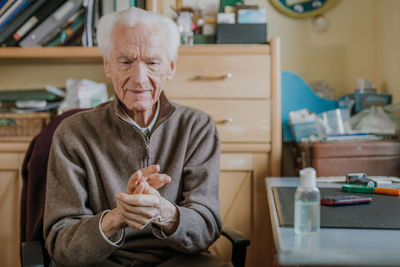 Portrait of man sitting on table at home