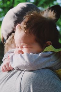 Side view of man carrying baby