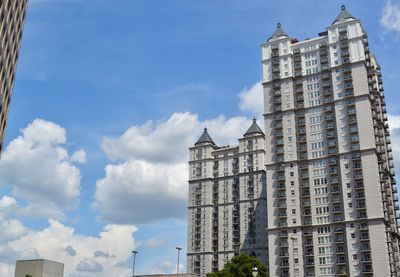 Low angle view of buildings against cloudy sky