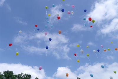 Low angle view of colorful balloons against blue sky