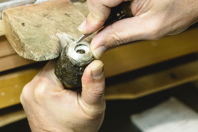 Close-up of man holding hands on table