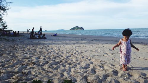 People on beach against sky