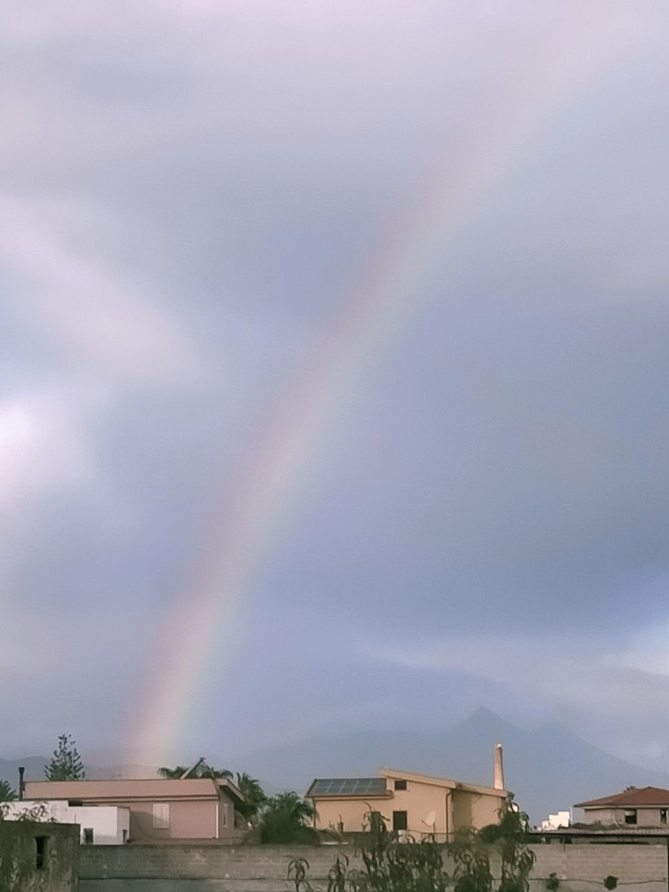 LOW ANGLE VIEW OF RAINBOW OVER BUILDINGS IN CITY