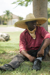 Man sitting on grass against trees