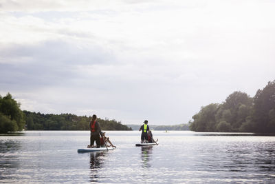 Mother and children paddle boarding