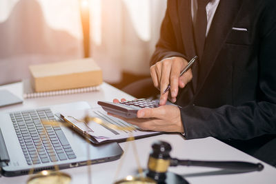 Midsection of man working on table