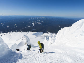 Two men climb down from the summit of mt. hood in oregon.